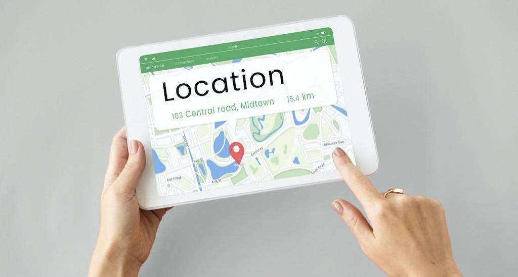 Location shown on a map on a white tablet monitor held by a person