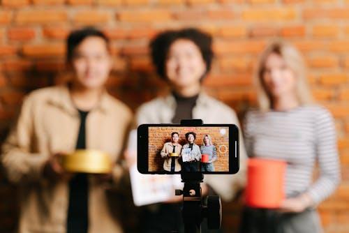A mounted phone monitor displaying three people standing against a brick wall