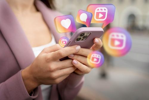 A person holding a mobile phone that shows social media post interaction on Instagram