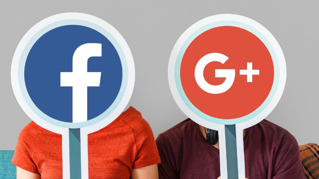 Two people holding up Facebook and Google logos to illustrate Google ads vs. Facebook ads